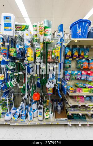 Komplett bestückte Regale mit Mops, Bürsten und anderen Reinigungsmitteln in einem Supermarkt Stockfoto