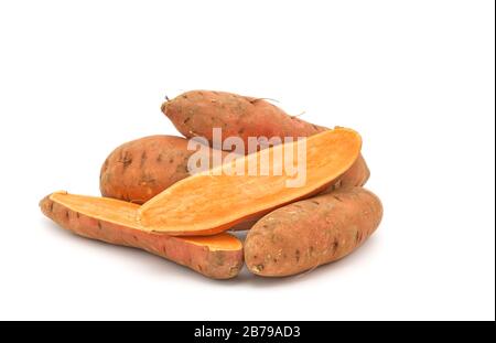 Ganze rohe orangefarbene Süßkartoffeln, Ipomoea Batatas fotografiert auf weißem Hintergrund mit viel Platz für Kopien. Stockfoto