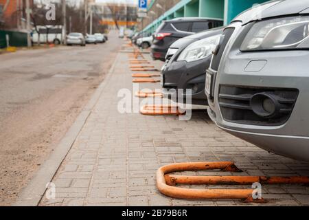 Autos sind auf privaten Einzelverpackungen. Private gelbe Metallverriegelung auf dem privaten Parkplatz Stockfoto