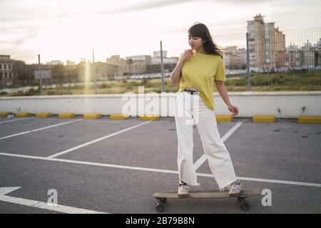 Weitwinkelaufnahme eines Mädchens auf einem Skateboard in Ein Park Stockfoto