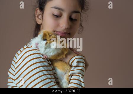 Mädchen im Jugendlichen, die ihr Meerschweinchen halten.Konzept "Liebe der Tiere" Stockfoto