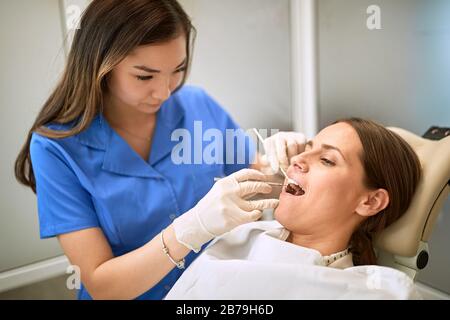 Junge Frau beim Zahnarzt, die den Zahn repariert Stockfoto