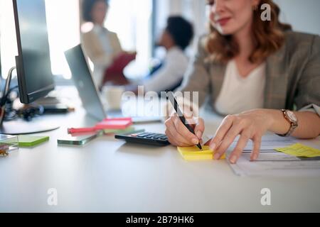 Hände der Geschäftsfrau, die etwas auf dem Papier niederschreibt Stockfoto