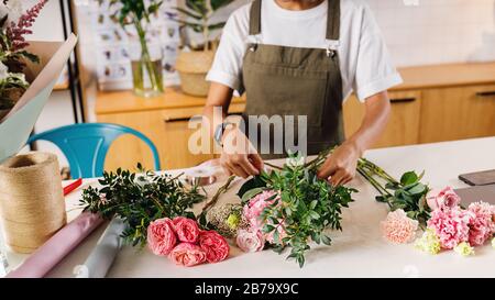 Unerkennbare Frau Floristin macht Blumenstrauß mit Blumen auf der Theke Stockfoto