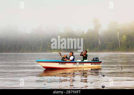 Touristen auf einem Flussboot auf dem Kinabatangan River, Sabah-Distrikt von Borneo auf einer Wildbeobachtung im Regenwald, Sabah, Borneo, Malaysia, Asien Stockfoto