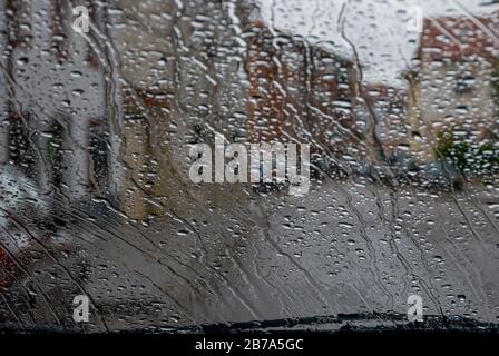 Regen durch die Fenster eines Autos Stockfoto