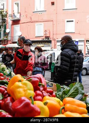 Neapel, Italien. März 2020. Menschen, die Schutzmasken und Handschuhe tragen, auf einem Markt in der Stadt Neapel, nachdem ein Regierungsdekret ganz Italien zu einem Schutzgebiet erklärt hatte, um die Kovid-19-Coronavirus-Infektion zu bekämpfen. Kredit: Unabhängige Foto-Agentur Srl/Alamy Live News Stockfoto
