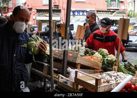 Neapel, Italien. März 2020. Menschen, die Schutzmasken und Handschuhe tragen, auf einem Markt in der Stadt Neapel, nachdem ein Regierungsdekret ganz Italien zu einem Schutzgebiet erklärt hatte, um die Kovid-19-Coronavirus-Infektion zu bekämpfen. Kredit: Unabhängige Foto-Agentur Srl/Alamy Live News Stockfoto