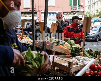 Neapel, Italien. März 2020. Menschen, die Schutzmasken und Handschuhe tragen, auf einem Markt in der Stadt Neapel, nachdem ein Regierungsdekret ganz Italien zu einem Schutzgebiet erklärt hatte, um die Kovid-19-Coronavirus-Infektion zu bekämpfen. Kredit: Unabhängige Foto-Agentur Srl/Alamy Live News Stockfoto