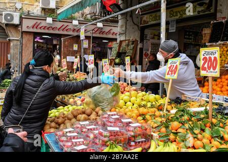 Neapel, Italien. März 2020. Menschen, die Schutzmasken und Handschuhe tragen, auf einem Markt in der Stadt Neapel, nachdem ein Regierungsdekret ganz Italien zu einem Schutzgebiet erklärt hatte, um die Kovid-19-Coronavirus-Infektion zu bekämpfen. Kredit: Unabhängige Foto-Agentur Srl/Alamy Live News Stockfoto