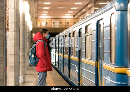 Der junge europäer ist in der U-Bahn in einer schützenden, medizinischen Gesichtsmaske. Neues Coronavirus (COVID-19). Konzept der Gesundheitsversorgung während eines Epigemi Stockfoto