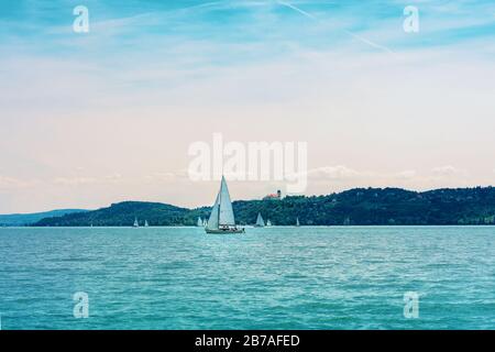 Segelboot auf dem Balaton Blick auf die Tihany Abteia von Balatonfured vor Sonnenuntergang Stockfoto