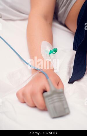 Infusionsflüssigkeit, intravenös mit Natriumchlorid, das auf die Hand des Patienten im Krankenhaus auftragen wird. Stockfoto