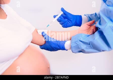 Schwangere Frauen im Arztbüro bekommen die Injektion in den Arm. Stockfoto