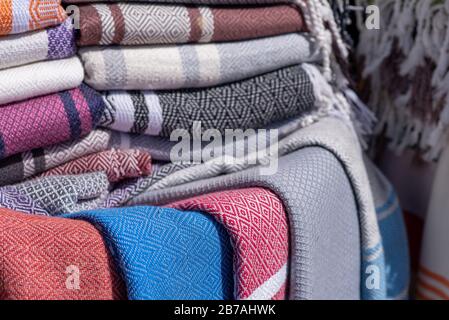 Lebhafte Stoffe, Textilien, Teppiche und Kissen zum Verkauf in den sonnigen Suken von Essaouira, Marokko Stockfoto