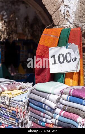 Lebhafte Stoffe, Textilien, Teppiche und Kissen zum Verkauf in den sonnigen Suken von Essaouira, Marokko Stockfoto