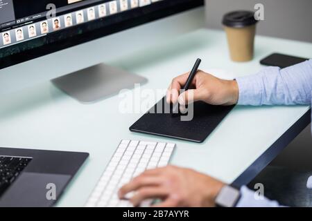 Hand von männlichen Designern arbeiten an seinem Schreibtisch mit Stift und digitalem Grafiktablett. Stockfoto