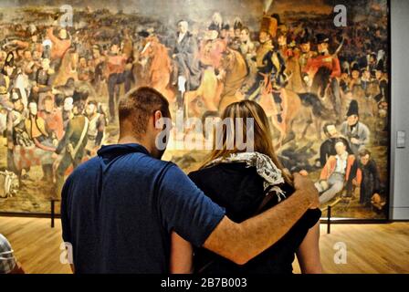 Ein kaukasisches Paar steht vor dem Gemälde "die Schlacht bei Waterloo" von Jan Willem Pieneman im Rijksmuseum in Amsterdam, Niederlande. Stockfoto