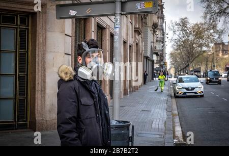 Ein Mann trägt eine große Gasmaske als Vorsichtsmaßnahme gegen die Verbreitung von Coronavirus in Barcelona.Nachdem die spanische Regierung die "Alarmgrenze" angeordnet hat, bleiben in Barcelona nur noch grundlegende Einrichtungen wie Supermärkte, Apotheken und Tabakhändler geöffnet. Stockfoto