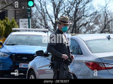 New Rochelle, New York, USA. März 2020. Staatlicher Trooper überprüft Autos am Kontrollpunkt. Das erste mobile Testzentrum COVID-19 des Staates in New Rochelle. Das mobile Testzentrum testet heute bis zu 200 Personen und wächst auf bis zu 500 Personen pro Tag. 14.03.20. New York, New Rochelle Glen Island Park. Marcus Santos Credit: Marcus Santos/ZUMA Wire/Alamy Live News Stockfoto