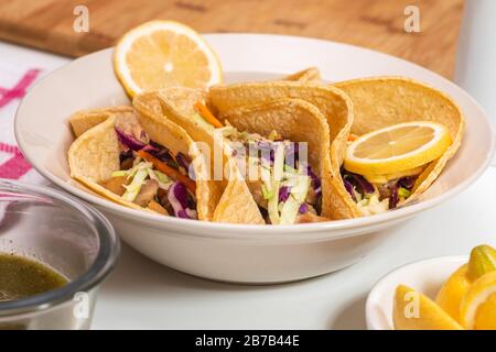 Hausgemachte Hühnertacos mit heißer Jalapeno-Paprika-Sauce und Limonade auf weißem Hintergrund Stockfoto