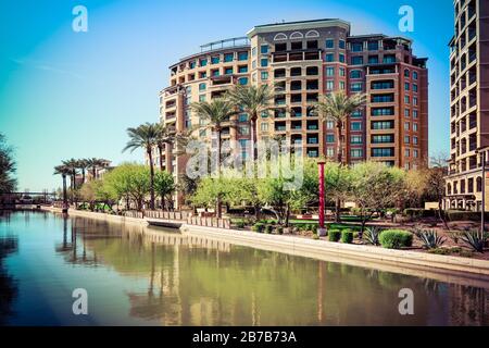 Große Condo-Gebäude mit unberührter Landschaftsgestaltung entlang des AZ-Kanals mit den luxuriösen Scottsdale Waterfront Residences in Scottsdale, AZ Stockfoto