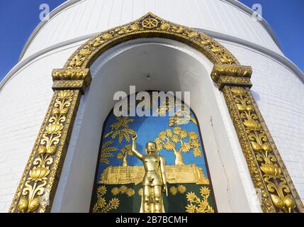 Wandbild mit Buddha-Statue, Shanti Stupa oder Weltfriedens-Pagode auf dem Anadi-Hügel oberhalb von Pokhara, Nepal Stockfoto