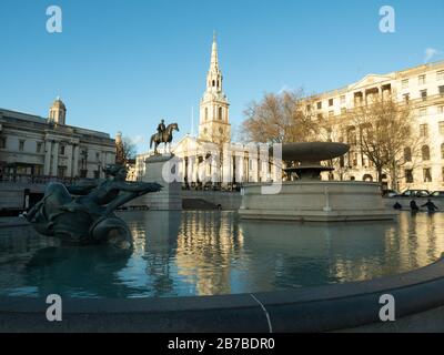 Trafalgar-Platz mit einem Brunnen im Vordergrund und St. Martin in der Field-Kirche dahinter Stockfoto