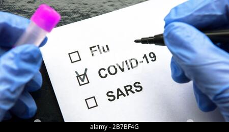 COVID-19-Coronavirus-Pandemiekonzept, Reagenzglas und Formular für Patientendokumente. Der Arzt markiert das Kontrollkästchen COVID-19 im Labor von Coronavirus. Novel SARS-COV- Stockfoto