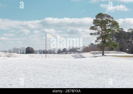 Yorktown, VA/USA-Februar 21.2020: Eine gelbe und weiße Flagge, die nach einem Winterschlager über dem schneebedeckten Schlachtfeld von Yorktown in Yorktown, Virginia, fliegt Stockfoto