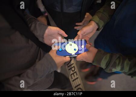 Zwei Hände halten das Handy und spielen ein Handy-App-Spiel Stockfoto