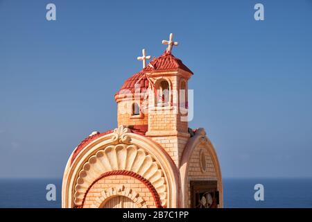 Kleine Straßenkapelle (Proskinitari) auf dem Parkplatz des Aussichtspunktes Petra tou Romiou bei Sonnenuntergang. Limassol. Zypern Stockfoto