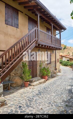 Der Blick auf die gepflasterte Straße des alten Kakopetria mit dem traditionellen Zweilasterhaus. Nikosia District. Zypern Stockfoto