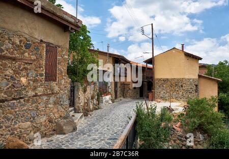 Der Blick auf die schmale, mittelalterlichen Straße der alten Kakopetria, umgeben von den traditionellen Häusern, die von Stein gesäumt sind. Nikosia District. Zypern Stockfoto