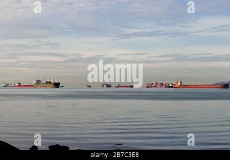 Vancouver, Kanada - 21. Februar 2020: Frachtschiffe warten darauf, im Burrard Inlet Harbor in Vancouver anzudocken Stockfoto