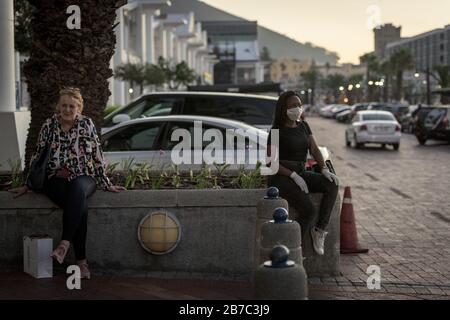 Portia Mkhwanazi spendet während der globalen Coronavirus Pandemie in Kapstadts beliebter südafrikanischer Touristenstadt eine Maske und Handschuhe Stockfoto