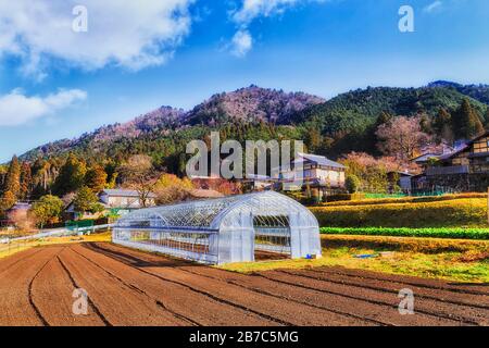 Gewächshaus auf einem gepflügten Bauernfeld im kleinen landwirtschaftlichen Dorf Ohara in Japan. Stockfoto