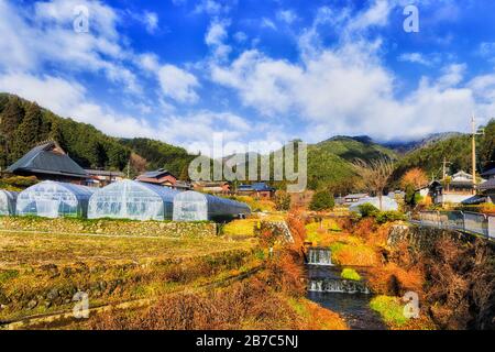 Kleiner Gebirgsfluss von fließendem Wasser durch das Bauerndorf Ohara in der Nähe der Stadt Kyoto in Japan an einem sonnigen Wintertag. Stockfoto