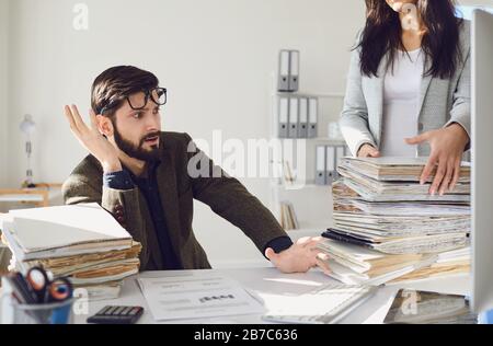 Arbeiter Unternehmer müde empört unglücklich sitzen am Arbeitsplatz Arbeit im Büro. Stockfoto