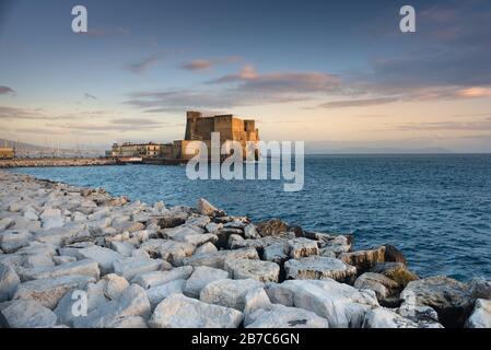 Castel dell'Ovo, Neapel. Einer der berühmtesten Orte Neapels, der von der untergehenden Sonne beleuchtet wird. Stockfoto