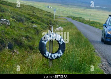 Hinweis auf Reifen mit dem englischen Text lammt langsam in den Highlands von Schottland Stockfoto