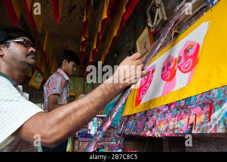 Proshanto Kumar das, Sohn von Raj Kumar das, am besten bekannt als RK das, einer der Rikschah-Künstler der ersten Generation in Bangladesch, ist mit dem Malen einer Rikschah-Kunst beschäftigt, während ihm seine Freude am 3. Mai 2012 in seinem Studio in der Hauptstadt Dhaka hilft. Die Rikscha-Kunst ist eine Form von Popkunst, die unsere urbane Kultur und Folklore von Bangladesch darstellt. Rickschas wurden erstmals in Bangladesch in den 1930er Jahren aus Japan eingeführt, wo die dreirädrigen Fahrzeuge als "nintaku" bekannt waren. Die Idee, die beingetriebenen Schmuggelware zu schmücken, ging in Bangladesch in den 1950er Jahren mit der Tradition nach dem einfachen, aber dennoch kolorfen Dorf aus Stockfoto