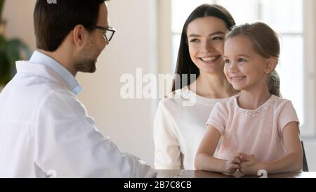 Glückliche junge Mutter besucht Kinderarzt mit Tochter. Stockfoto