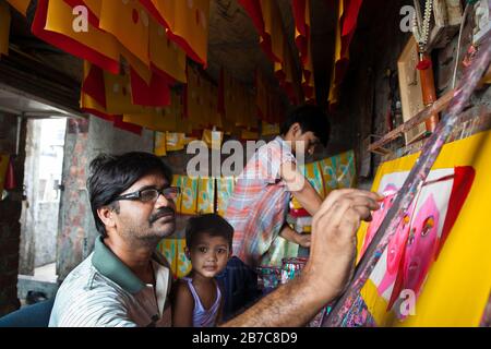 Proshanto Kumar das, Sohn von Raj Kumar das, am besten bekannt als RK das, einer der Rikschah-Künstler der ersten Generation in Bangladesch, ist mit dem Malen einer Rikschah-Kunst beschäftigt, während ihm seine Freude am 3. Mai 2012 in seinem Studio in der Hauptstadt Dhaka hilft. Die Rikscha-Kunst ist eine Form von Popkunst, die unsere urbane Kultur und Folklore von Bangladesch darstellt. Rickschas wurden erstmals in Bangladesch in den 1930er Jahren aus Japan eingeführt, wo die dreirädrigen Fahrzeuge als "nintaku" bekannt waren. Die Idee, die beingetriebenen Schmuggelware zu schmücken, ging in Bangladesch in den 1950er Jahren mit der Tradition nach dem einfachen, aber dennoch kolorfen Dorf aus Stockfoto