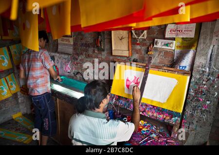 Proshanto Kumar das, Sohn von Raj Kumar das, am besten bekannt als RK das, einer der Rikschah-Künstler der ersten Generation in Bangladesch, ist mit dem Malen einer Rikschah-Kunst beschäftigt, während ihm seine Freude am 8. Mai 2012 in seinem Studio in der Hauptstadt Dhaka hilft. Die Rikscha-Kunst ist eine Form von Popkunst, die unsere urbane Kultur und Folklore von Bangladesch darstellt. Rickschas wurden erstmals in Bangladesch in den 1930er Jahren aus Japan eingeführt, wo die dreirädrigen Fahrzeuge als "nintaku" bekannt waren. Die Idee, die beingetriebenen Schmuggelware zu schmücken, ging in Bangladesch in den 1950er Jahren mit der Tradition nach dem einfachen, aber dennoch kolorfen Dorf aus Stockfoto