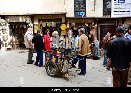 Fes, Marokko - 20. November 2014: Nicht identifizierte Personen auf Place es-Seffarine in Souk Fes el-Bali, Straßenhändler mit Radkarre Stockfoto