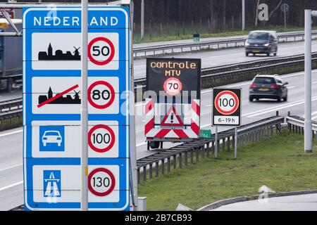 De Poppe, Niederlande. März 2020. Die Geschwindigkeit 100 von 6 bis 19 Uhr ist auf einem Verkehrsschild auf einer Autobahn an der Grenze zwischen den Niederlanden und Deutschland zu finden. Nach Norwegen und Zypern führen die Niederlande auch auf allen Autobahnen ein 100-km/h-Tempolimit ein. Credit: Friso Gentsch / dpa / Alamy Live News Stockfoto