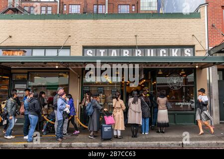 Seattle, Washington, USA - 9. Oktober 2019: Menschen, die in langen Warteschlangen warten, um im ersten Starbucks Shop des Pike Place Market zu sein. Stockfoto