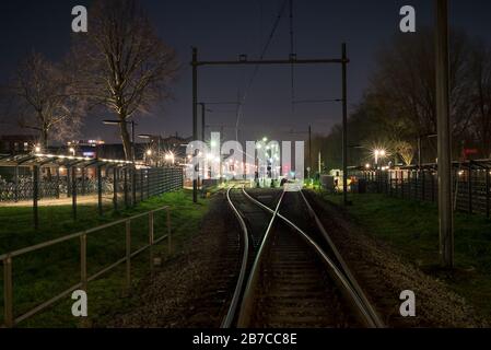 Nachtansicht des Bahnknotenpunktes in der Nähe eines kleinen Bahnhofs in einer Stadt in Holland Stockfoto