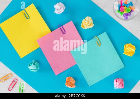 Bunte Karten mit Platz für eine Beschriftung, Büro- oder Geschäftskonzept, Heftklammern, zerknitterten Papierkugeln. Stockfoto